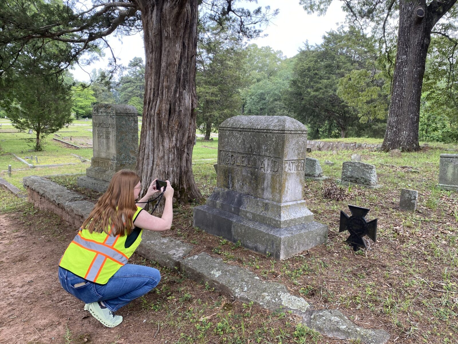 New South Associates team member studies headstone in cemetery. 